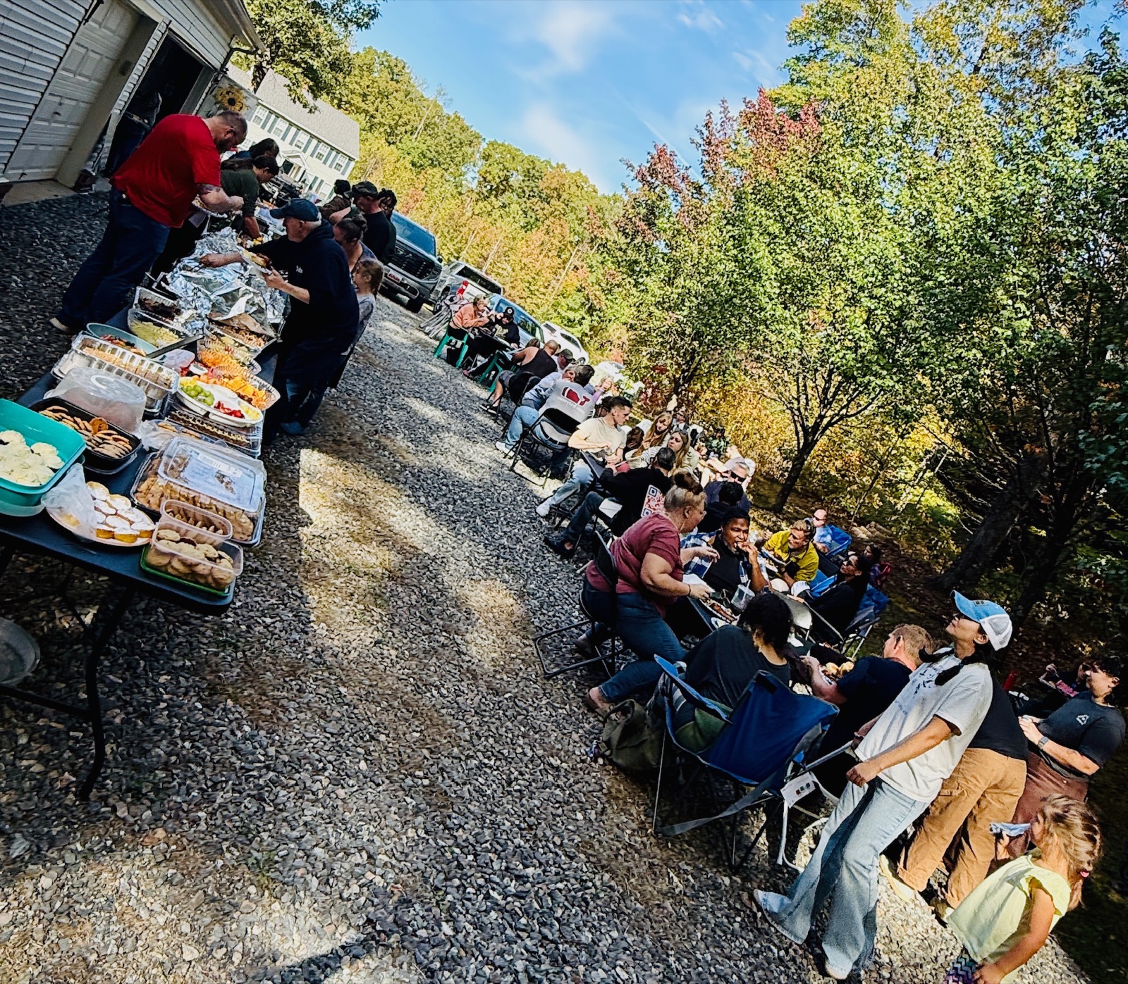 Guests gathered at Smoked MeatFest — tables of food, fall foliage